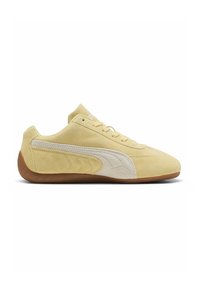 Baskets basse beige en daim avec une bande latérale blanche, un design à lacets et une semelle en caoutchouc marron texturée, vues de profil droit.