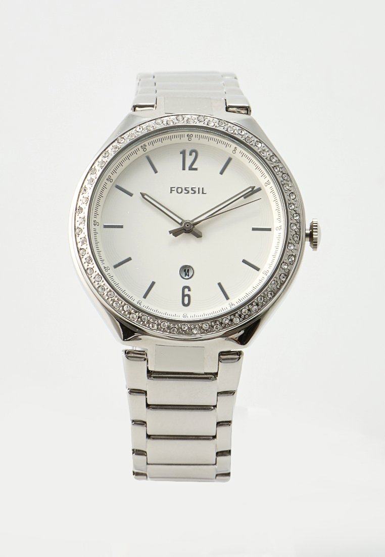 Montre en acier inoxydable argenté avec un cadran blanc, lunette ornée de cristaux et aiguilles des heures et des minutes métalliques. Présente un affichage de la date à 6 heures.
