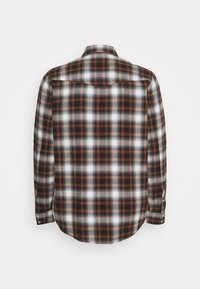 Camisa de cuadros de manga larga en naranja, negro y blanco. Presenta un cuello con botones, un dobladillo redondeado y botones en los puños.