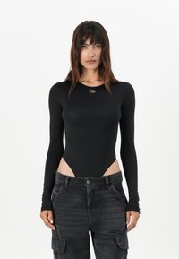 Černý bodysuit s dlouhým rukávem a vykrojenými boky. Hladká textura a přiléhavý design. Má kulatý výstřih a malé logo na hrudi.
