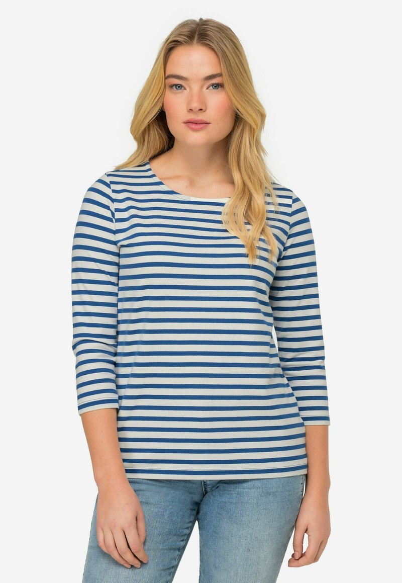 Blå och vit randig långärmad skjorta med rund halsringning och mjukt tyg. Kombinerad med ljusblå jeans som har en avslappnad passform.