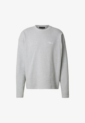 Szürke hosszú ujjú pulóver texturált kötött anyagból, kerek nyakkivágással és finom fehér logóval a mellrészen. Laza szabás és egyszerű dizájn.