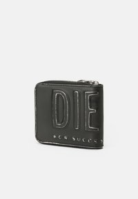 Carteira de couro preta com texto em relevo "DIE FOR SUCCESS." Possui fecho de zip e costura em contraste. Forma retangular compacta.