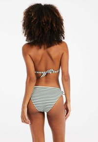 Bikini a righe verde e bianco. La parte superiore presenta un dettaglio con laccetto sul retro, mentre la parte inferiore ha una vita alta con una vestibilità aderente. Tessuto liscio.
