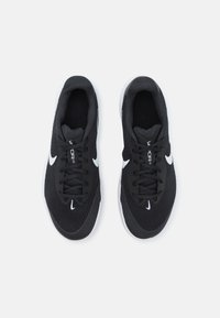 Crne atletske cipele s mrežastim gornjim dijelom, bijelim Nike swoosh logom, vezicama, podstavljenim ovratnikom i teksturiranim potplatom. Dizajn je usmjeren na laganu izvedbu.