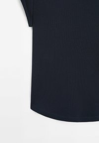 Marinblå bomullströja med korta ärmar, rund halsringning och en böjd nederkant. Slät textur utan mönster eller dekorationer.