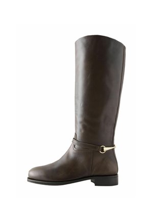 Botte d'équitation haute en cuir marron foncé avec petit talon et sangle décorative avec boucle dorée autour de la cheville, vue de côté.