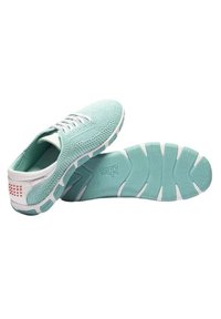 Chaussures de sport légères vert menthe avec un dessus en maille texturée, des lacets blancs et une semelle extérieure en caoutchouc flexible dotée de motifs de grip.