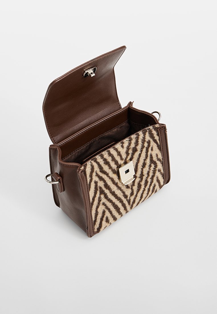 Braune Lederhandtasche mit einem vorne aus Zebra-gestreiften Wolle, silbernem Zubehör und einem Magnetverschluss. Der Innenraum ist ungefüttert.