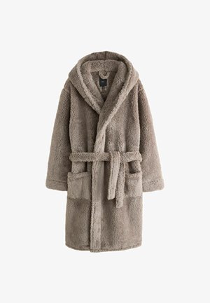 Baardige man met een dikke, beige, gestructureerde fleece jas met een grote kraag tegen een effen grijze achtergrond.