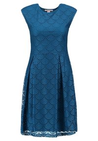 Robe en dentelle teal avec un motif en vagues, encolure ronde et sans manches. Forme en A avec une jupe évasée et des détails à l'ourlet.