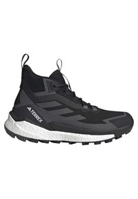 Chaussure de trail running montante noire et grise avec semelle blanche amortie et marquage "TERREX" sur le côté, conçue pour un usage extérieur.