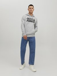 Gray hoodie with front kangaroo pocket and black logo text. Paired with blue straight-leg jeans and white sneakers. Smooth fabric texture.