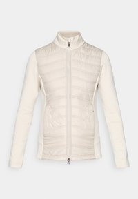 Lätt creamfärgad zip-up jacka, vadderad front med horisontella stygn, släta ärmar, hög krage och två sidofickor.