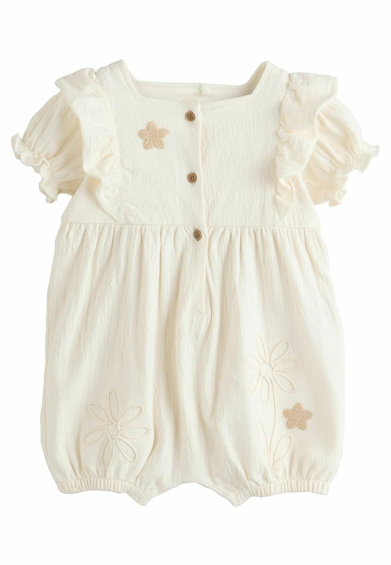 Romper en coton crème avec des manches volantes, trois boutons en bois et broderie florale sur le devant. Tissu doux et texturé.
