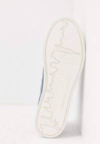 Podešev modré tenisky s vyraženým panorama New Yorku a Sochou svobody s brandingem Tommy Hilfiger.