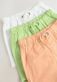 Drei Shorts-Paare: weiß, hellgrün und pfirsichfarben. Sie verfügen über elastische Taillenbänder, Zugschnüre und seitliche Taschen. Weicher, glatter Stoff.