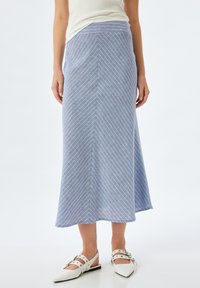 Hellblauer Midirock mit weißen diagonalen Streifen, hergestellt aus weichem Stoff. Ausgestellt geschnitten, glatte Textur und ein Bündchen für einen sicheren Sitz.