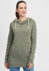 Olivgrön huvtröja gjord av mjukt tyg, med en cowl-hals, kontrasterande dragsnören och triangulära läderdetaljer på fickorna.