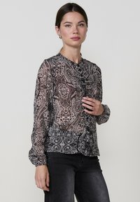 Fekete, áttetsző blúz, paisley mintával, hosszú ujjak, gallér és gombok az elején. Puha tapintású, sötét farmernadrággal párosítva.