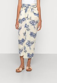 Blomstret wrap-skirt med en cremefarvet baggrund, prydet med blå blomster- og bladmønstre, bundet i taljen og med en lige silhuet.