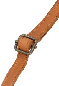 Skórzany pasek w kolorze tan z widocznym szwem oraz prostokątną metalową klamrą. Pasek ma gładką fakturę z delikatnymi akcentami z zamszu.