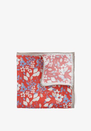 Czerwona koc z kwiatowym wzorem w niebieskie i białe wzory, z kontrastowym jasnobeżowym wykończeniem i różowym spodem z kwiatowymi akcentami.