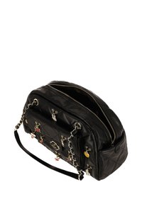 Bolso de mano de cuero negro acolchado con herrajes plateados, detalles de cadena y varios charms coloridos. Cuenta con una cremallera en la parte superior y una correa de hombro desmontable.
