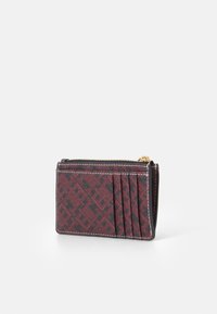 Cardholder featuring a red and black geometric pattern, made of textured material, with a zip closure and multiple card slots on one side.
