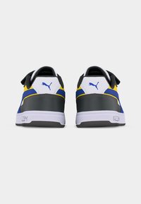 Ζεύγος χαμηλών αθλητικών παπουτσιών σε λευκό, μπλε, κίτρινο και μαύρο χρώμα, εμφωβισμένα από πίσω, με λογότυπα Puma στις ταμπελίτσες του τακουνιού.