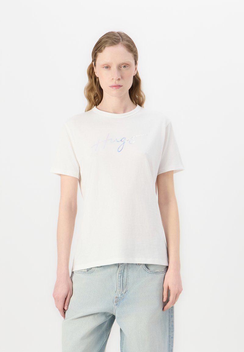 Tricou scurt cu mânecă albă, din bumbac, cu text irizant "Hugs" pe față. Design drept, textură moale și tăietură lejeră.
