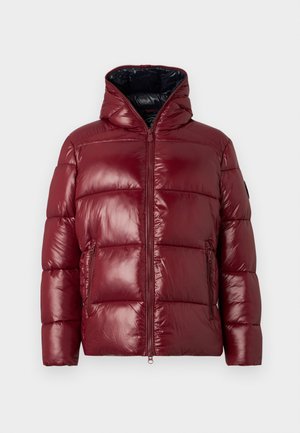 Bordo steppelt dzseki magas gallérral, elülső cipzárral és két cipzáras oldalsó zsebbel, egy sima háttér előtt bemutatva.