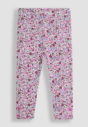 Leggings infantiles con un denso estampado floral en rosa, morado y rojo sobre fondo blanco, que presentan pequeños botones rosas cerca de los tobillos.