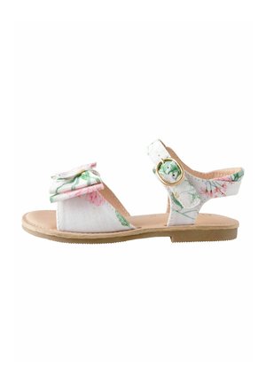 Sandali con motivo floreale, caratterizzati da una tomaia in tessuto bianco con dettagli in rosa e verde, chiusura con fibbia sulla cinghia e suola piatta color ocra.