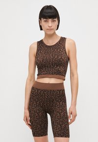 Hnedý top s leopardím vzorom a zodpovedajúce cyklistické šortky vyrobené z mäkkej, elastickej látky s priliehavým strihom a rebrovanými pásmi.