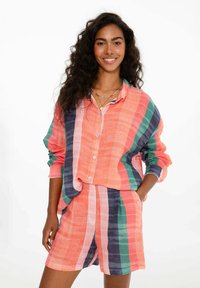 Linenová súprava košele a šortiek v koralovej, námorníckej a zelenej pruhovanej farbe; košeľa s gombíkmi má voľný strih; šortky majú vrecká a elastický pás.