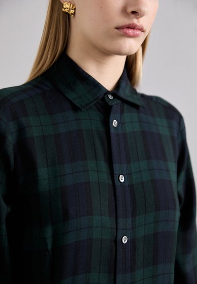 Plaid shirt in dark green and navy blue with a button-up design, featuring a pointed collar and smooth texture. Buttons are silver.