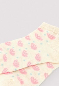 Calcetines tobilleros de color crema con un patrón de coronas rosas y pequeños puntos azules, tejido de punto con puños acanalados.