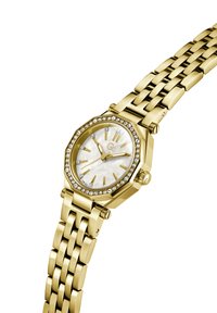 Zlaté hodinky s oktagónovým puzdrom, bielym perleťovým ciferníkom, striebornými indexmi a puzdrom zdobeným kryštálmi. Kovový náramok s článkami.