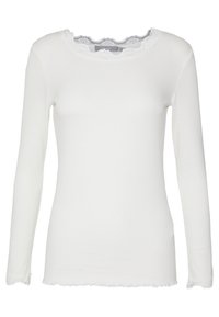 Chemise blanche à manches longues en maille côtelée avec bordure en dentelle au col rond, aux poignets et à l'ourlet, conçue pour le port décontracté féminin.