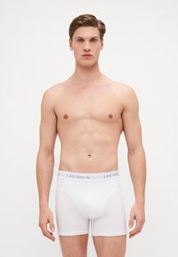 Caleçons boxers blancs en mélange de coton doux, avec une taille élastique arborant le logo "LES DEUX", un design ajusté et une texture lisse.
