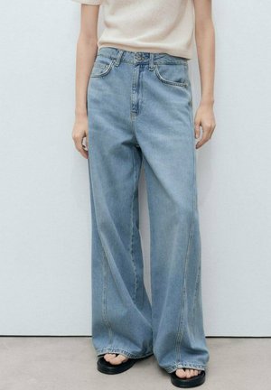 Light blue wide-leg jeans made of denim, featuring a high waist, visible stitching, and side pockets. Worn with black sandals.