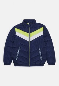 Giacca puffer blu navy con colletto alto, caratterizzata da strisce a zig-zag verdi e bianche sul petto e testo stampato sulle maniche.
