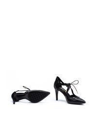 Zapatos de tacón alto negros con diseño de punta afilada, hechos de cuero suave. Cuentan con lazos en los tobillos y una suela de goma texturizada para mayor agarre.
