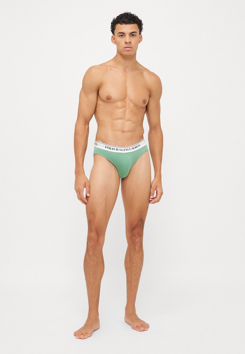 Grüner Herren-Thong mit einem weißen elastischen Bund, der mit schwarzem "POLO RALPH LAUREN"-Branding versehen ist. Weiches Material, enge Passform und minimalistisches Design.