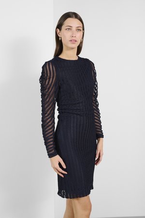 Vestido azul marino hecho de tela texturizada con rayas horizontales, mangas largas y transparentes, y una silueta ajustada, que presenta un dobladillo con forma de concha.
