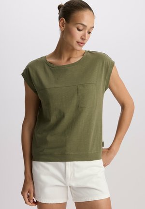 Oliwkowa bluzka z krótkim rękawem, okrągłym dekoltem, kieszonką na piersi i luźnym krojem. Teksturowany materiał o lekko skróconym fasonie.