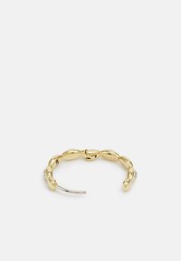 Bracelet doré avec des formes ovales entrelacées, finition polie et accent argenté. Comprend de petits détails transparents près de la fermeture.