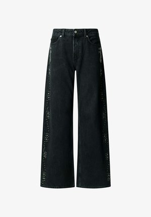 Jeans denim noirs à jambes larges avec bouton en métal et rivets, présentant des motifs décoratifs en clous argentés le long des coutures extérieures des deux jambes.