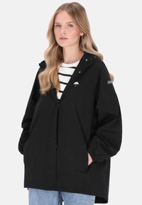 Fekete vízálló dzseki kapucnival, rugalmas mandzsettákkal és patentos záródással. Mellrészen esernyő logóval és oldalzsebekkel rendelkezik.